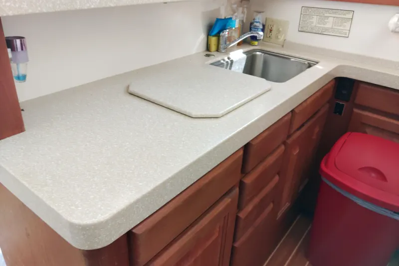 Slide: The Image of 1999 Viking 45 Convertible kitchen with sink, countertop, and red trash bin. - 40
