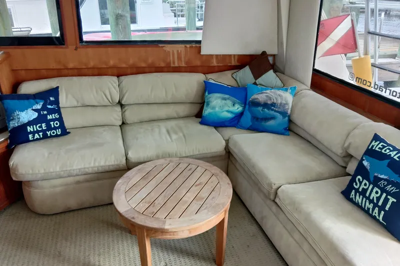 Slide: The Image of Cozy interior of 1999 Viking 45 Convertible with shark-themed pillows and wooden table. - 45