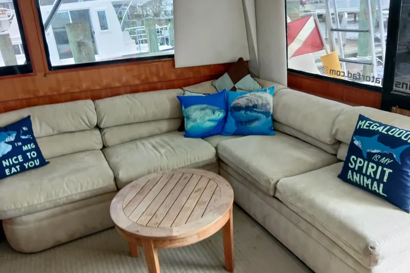 Slide: The Image of Cozy interior of 1999 Viking 45 Convertible with shark-themed pillows and round wooden table. - 46
