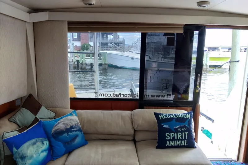 Slide: The Image of Interior of a 1999 Viking 45 Convertible yacht with shark-themed pillows. - 49