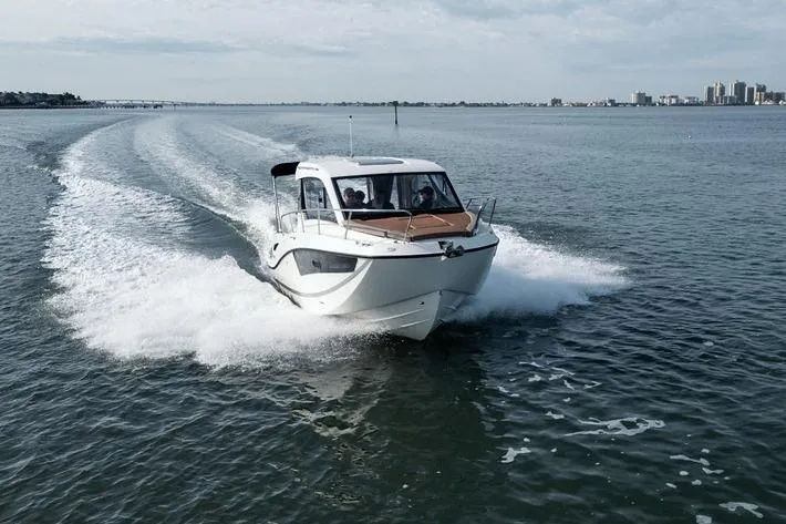 Slide: The Image of 2026 Trophy T25EX EXPLORER OB boat cruising on open water, city skyline in background. - 3