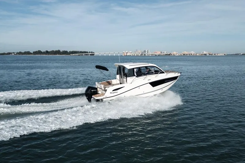 Slide: The Image of 2026 Trophy T25EX Explorer OB boat cruising on open water, cityscape in background. - 4