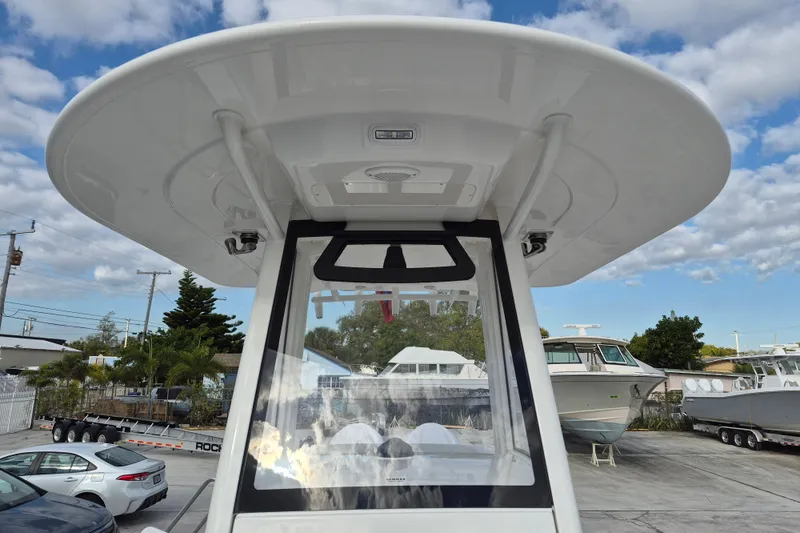 Slide: The Image of 2026 Regulator 25 boat with T-top, parked in marina under cloudy sky. - 10