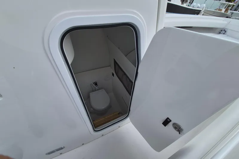 Slide: The Image of 2026 Regulator 25 boat interior with open door revealing compact marine toilet. - 14