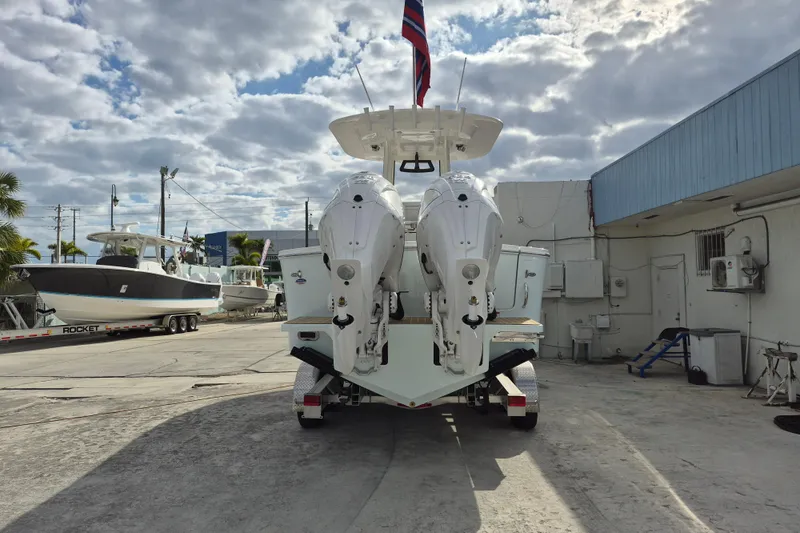 Slide: The Image of 2026 Regulator 25 boat with dual engines on a trailer, under a cloudy sky. - 16