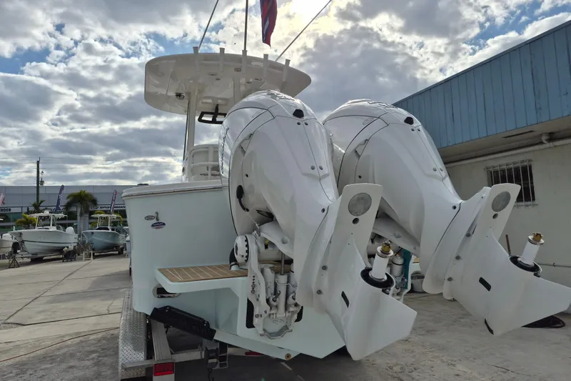 Slide: The Image of 2026 Regulator 25 boat with dual outboard motors, docked under a cloudy sky. - 17