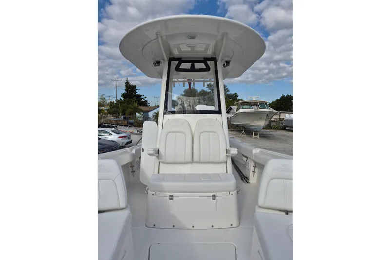 Slide: The Image of 2026 Regulator 25 boat interior with seating and T-top under a cloudy sky. - 9