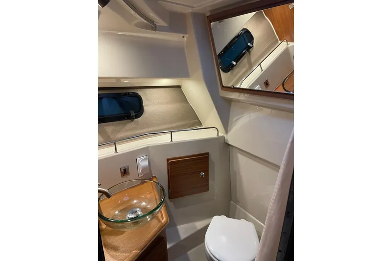 Slide: The Image of 2026 Ranger Tug R-27 boat bathroom with glass sink and mirror. - 12