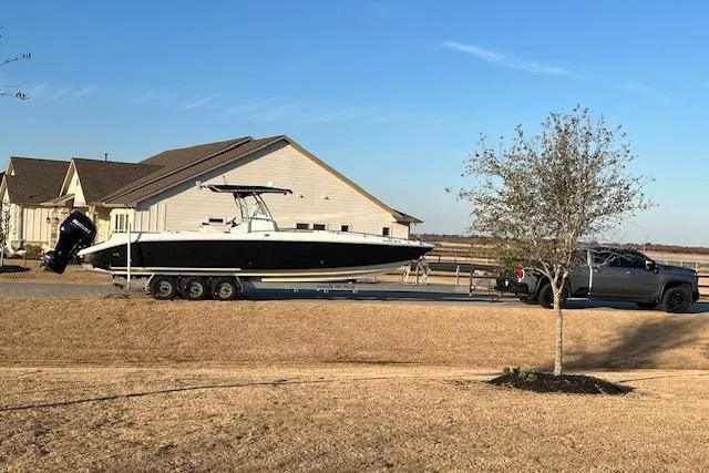 The Image of 2002 Baja 340 Islander Outboard boat on trailer, parked near a house. - 0