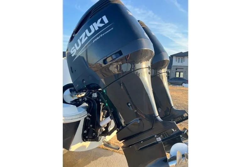 Slide: The Image of Twin Suzuki outboard engines on a 2002 Baja 340 Islander boat, parked outdoors. - 5