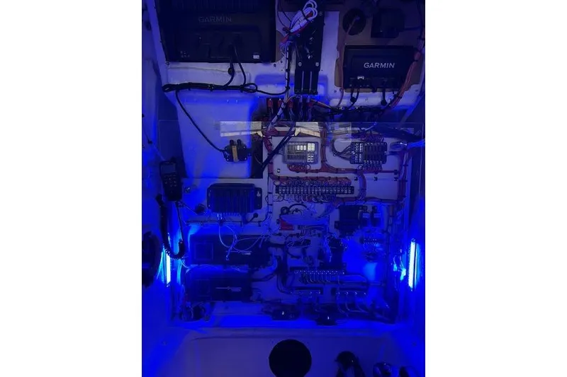 Slide: The Image of Electrical panel of a 2002 Baja 340 Islander Outboard, illuminated with blue lighting. - 9