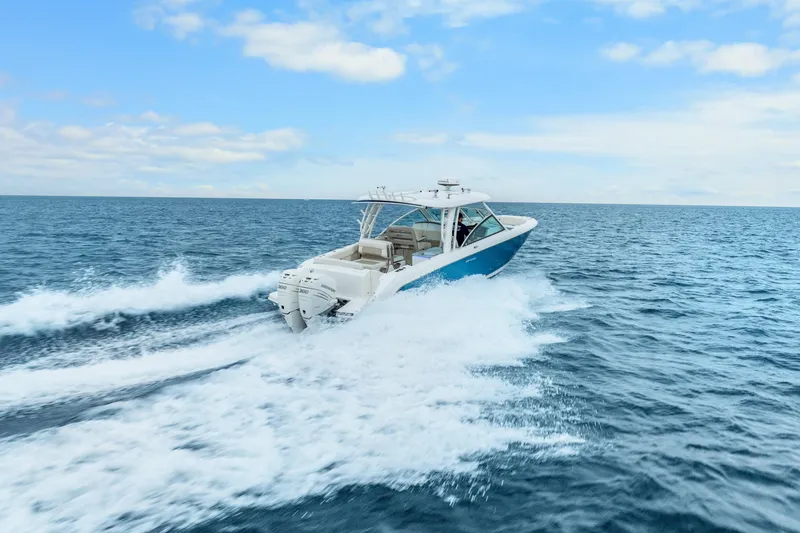 Slide: The Image of 2018 Boston Whaler 320 Vantage cruising on open ocean under blue sky. - 2