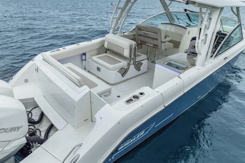 Slide: The Image of 2018 Boston Whaler 320 Vantage boat on water, showcasing spacious deck and seating. - 25