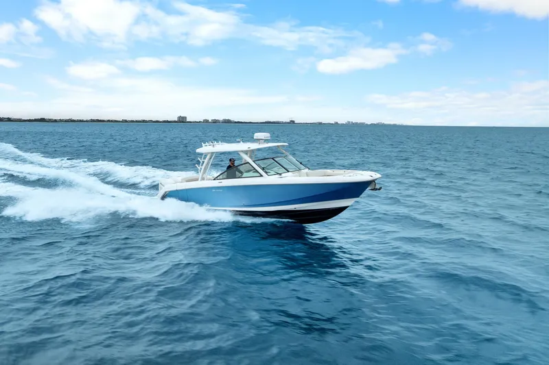Slide: The Image of 2018 Boston Whaler 320 Vantage cruising on open blue ocean under clear sky. - 3