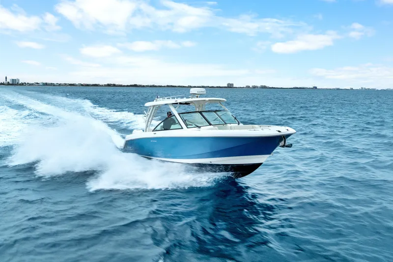 Slide: The Image of 2018 Boston Whaler 320 Vantage cruising on open blue ocean under clear sky. - 4