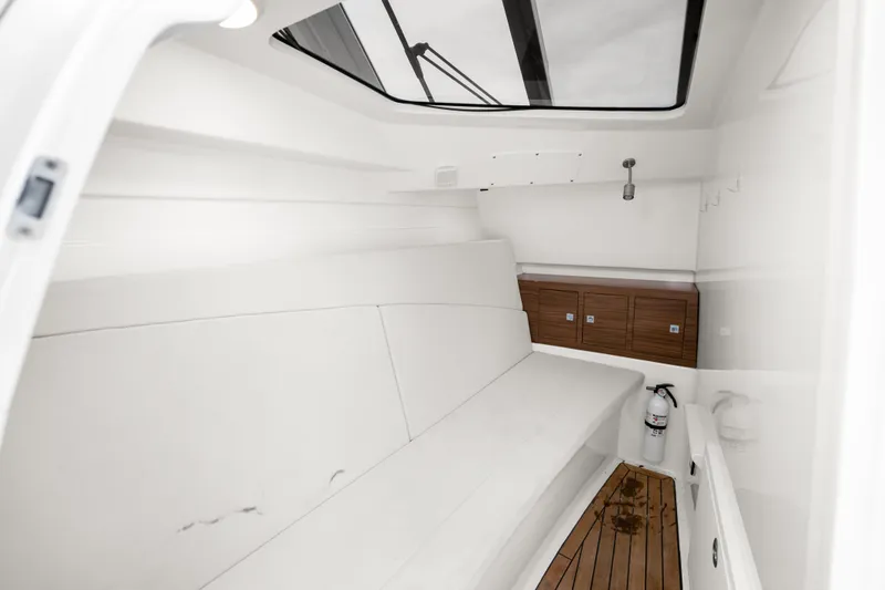 Slide: The Image of Interior cabin of 2018 Boston Whaler 320 Vantage with white seating and wooden accents. - 44