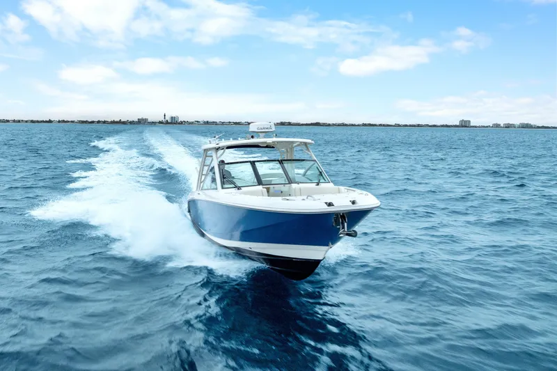 Slide: The Image of 2018 Boston Whaler 320 Vantage cruising on open blue ocean under clear sky. - 5