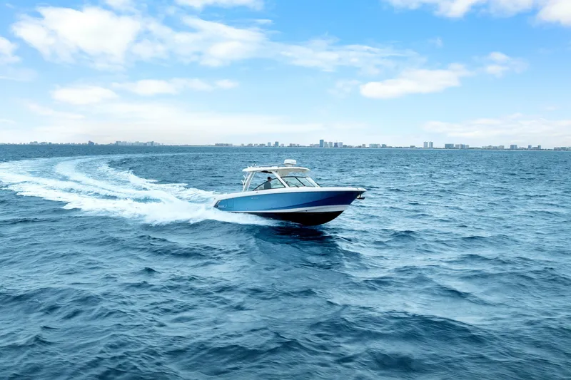 Slide: The Image of 2018 Boston Whaler 320 Vantage cruising on open ocean under clear blue sky. - 7