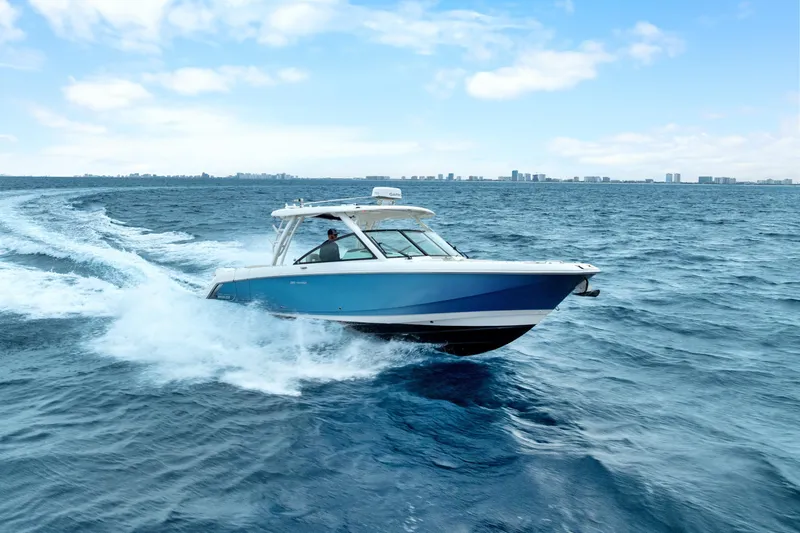 Slide: The Image of 2018 Boston Whaler 320 Vantage cruising on open ocean under clear blue sky. - 8