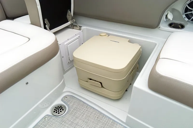 Slide: The Image of 2024 Crownline Eclipse E210 XS boat interior with portable toilet and seating area. - 10