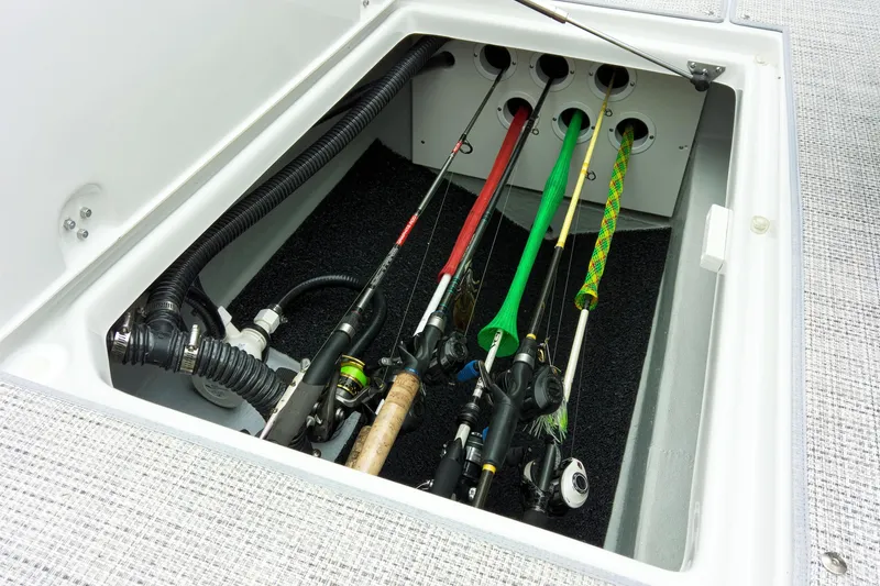 Slide: The Image of 2024 Crownline Eclipse E210 XS boat rod storage compartment with fishing rods. - 16