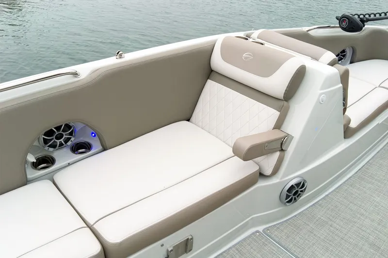 Slide: The Image of 2024 Crownline Eclipse E210 XS boat interior with beige and white seating, cup holders, and speakers. - 18