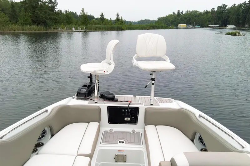 Slide: The Image of 2024 Crownline Eclipse E210 XS boat interior on a serene lake. - 19