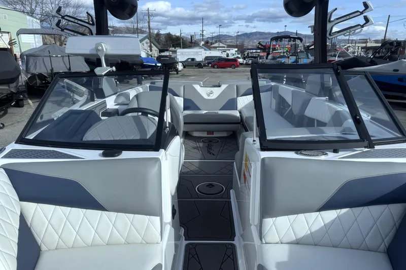 Slide: The Image of 2022 Tigé Z3 boat interior with modern seating and dashboard, parked outdoors. - 12