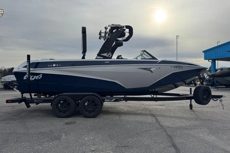 Slide: The Image of 2022 Tigé Z3 boat on trailer under cloudy sky. - 3