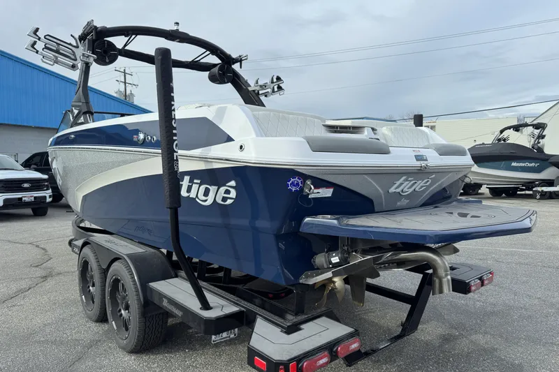 Slide: The Image of 2022 Tigé Z3 boat on trailer, blue and white design, parked outdoors. - 4