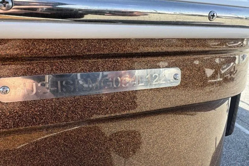 Slide: The Image of 2022 Moomba Craz boat with metallic brown finish and identification plate. - 10