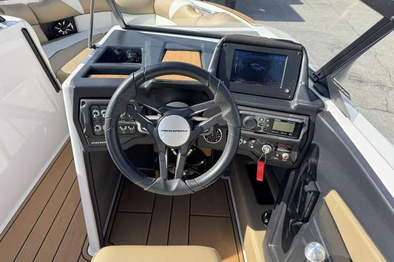 Slide: The Image of 2022 Moomba Craz boat dashboard with steering wheel and control panel. - 12