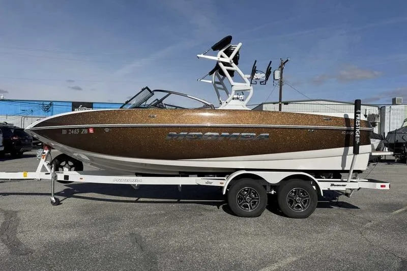Slide: The Image of 2022 Moomba Craz boat on trailer, brown and white, parked outdoors. - 4