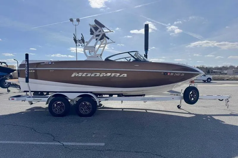 Slide: The Image of 2022 Moomba Craz boat on trailer under clear blue sky. - 6