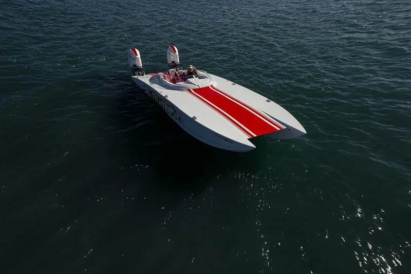Slide: The Image of 2022 HellKats 32 powerboat with red stripe, cruising on open water. - 18