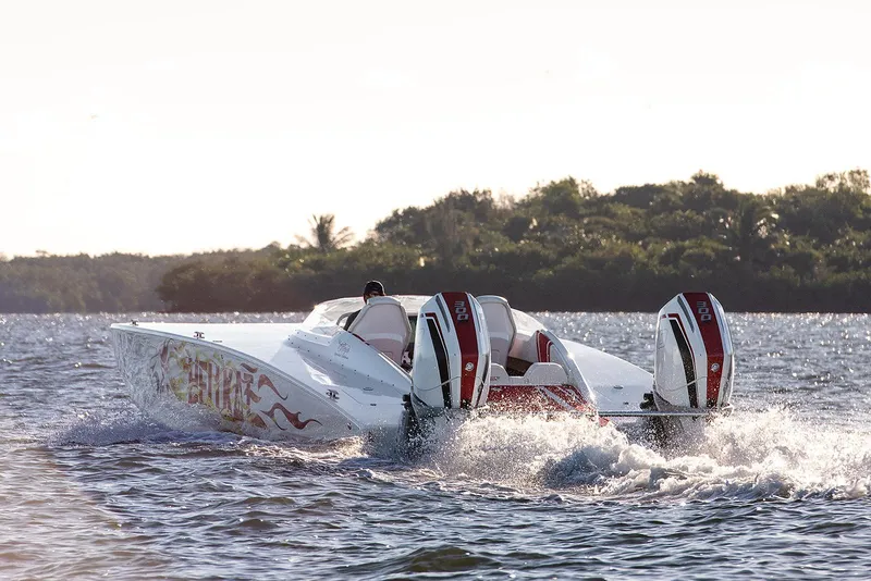 Slide: The Image of 2022 HellKats 32 speedboat cruising on water with dual engines, scenic background. - 3