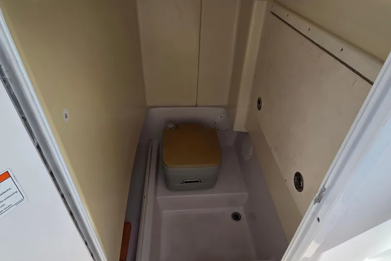 Slide: The Image of 2008 Pro-Line 24 Super Sport boat interior with compact portable toilet. - 11