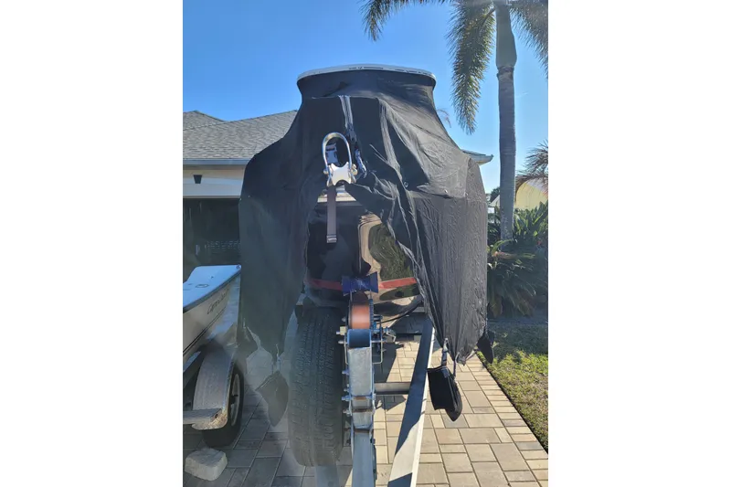 Slide: The Image of 2008 Pro-Line 24 Super Sport boat covered on trailer, sunny day, palm trees in background. - 19