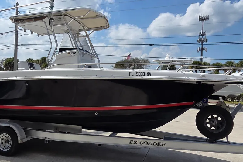 Slide: The Image of 2008 Pro-Line 24 Super Sport boat on EZ Loader trailer, black hull, outdoor setting. - 2