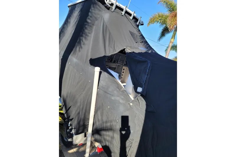 Slide: The Image of 2008 Pro-Line 24 Super Sport boat covered with a black tarp, partially torn. - 23