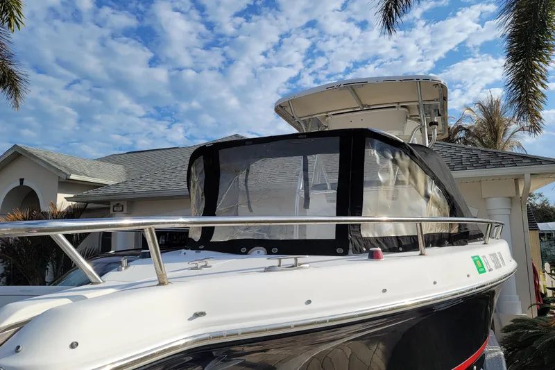 Slide: The Image of 2008 Pro-Line 24 Super Sport boat docked near a house under a blue sky. - 26