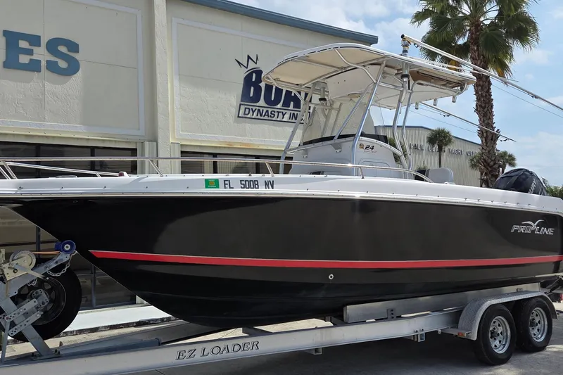 Slide: The Image of 2008 Pro-Line 24 Super Sport boat on trailer, parked outside a building. - 3