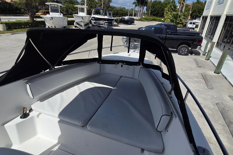 Slide: The Image of 2008 Pro-Line 24 Super Sport boat with cushioned seating and canopy in a marina setting. - 9