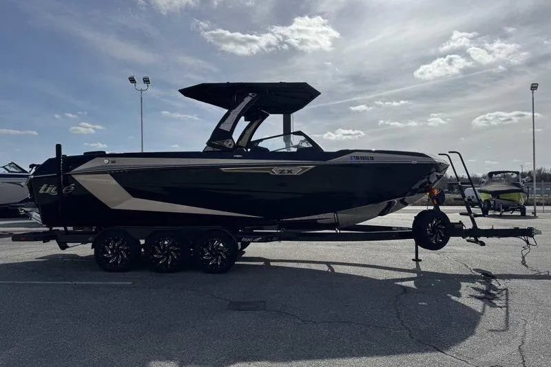 Slide: The Image of 2025 Tigé Ultré 25ZX boat on trailer under cloudy sky. - 4