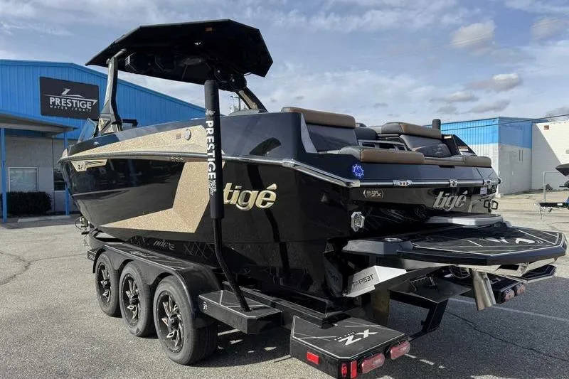 Slide: The Image of 2025 Tigé Ultré 25ZX boat on trailer at Prestige dealership, showcasing sleek design. - 6