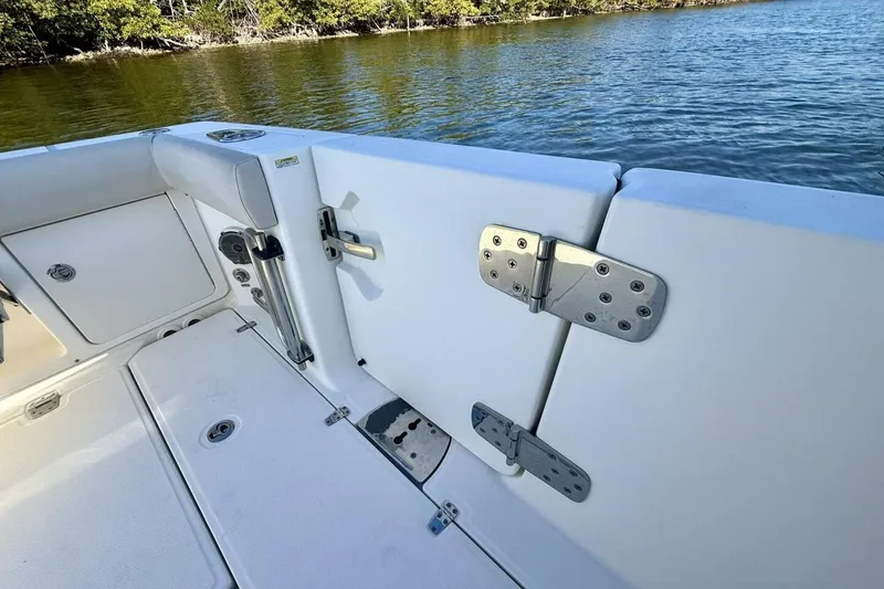 Slide: The Image of 2018 Boston Whaler 330 Outrage boat interior, featuring a secure transom door and scenic water view. - 44