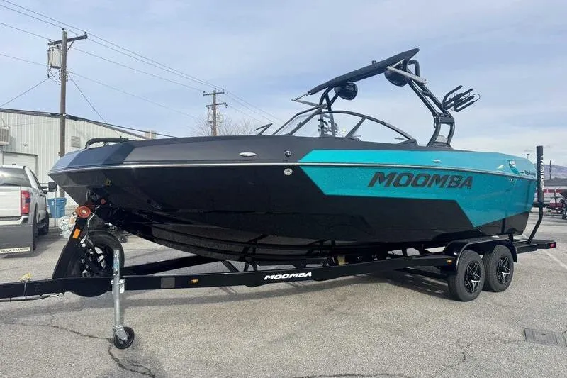 The Image of 2026 Moomba Tykon boat on trailer, black and teal design, parked outdoors. - 0