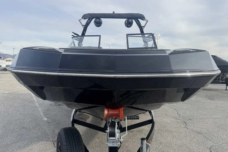 Slide: The Image of 2026 Moomba Tykon boat on trailer, front view, sleek black design. - 5