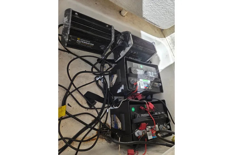 Slide: The Image of Batteries and alternators in a 2021 Key West 189 FS boat, with visible wiring. - 15