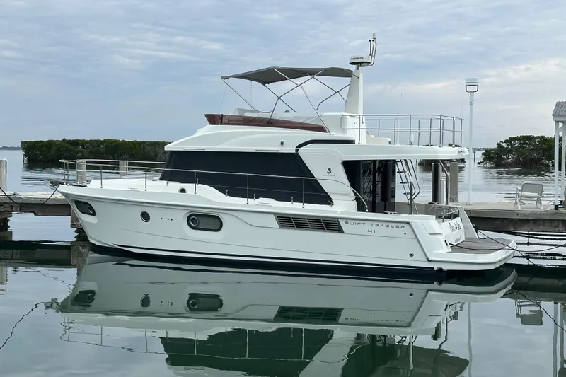 Slide: The Image of 2021 Beneteau Swift Trawler 41 Fly docked, reflecting on calm water. - 0